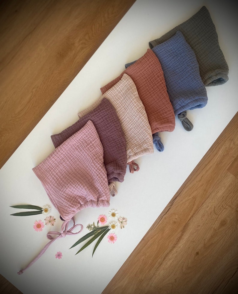 Sechs Zwergenmützen aus Musselin für Kleinkinder in Olive, Meeresblau, Orange, Natur, Altrosa, Lehmrosa.