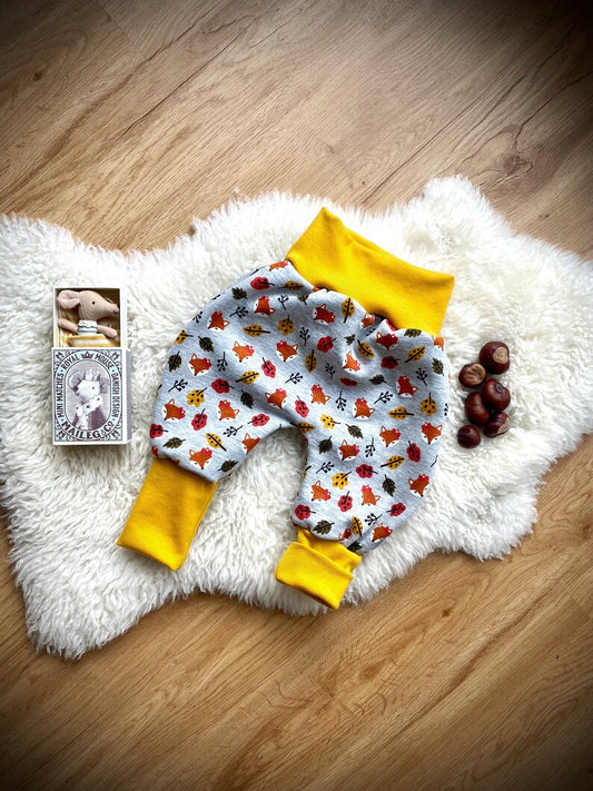 Pumphose für Kleinkinder aus Alpenfleece mit grauem Hintergrund und gelben Bündchen.