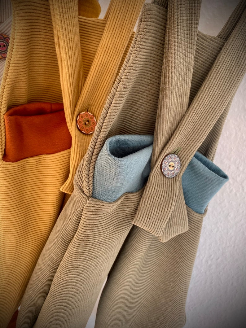 Rückansicht von zwei Knickerbockerhosen für Kleinkinder in hellbraund und olive.