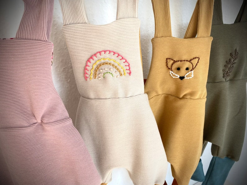 Nahaufnahme von vier Knickerbockerhosen für kleinkinder in rosa, beige, hellbraun und olive.
