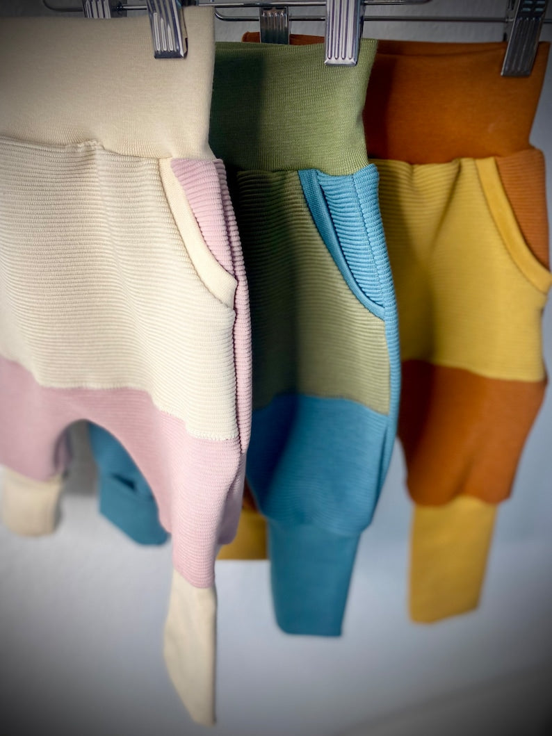 Drei Mix and Match Pumphosen für Kleinkinder in rosa, blau und rot.