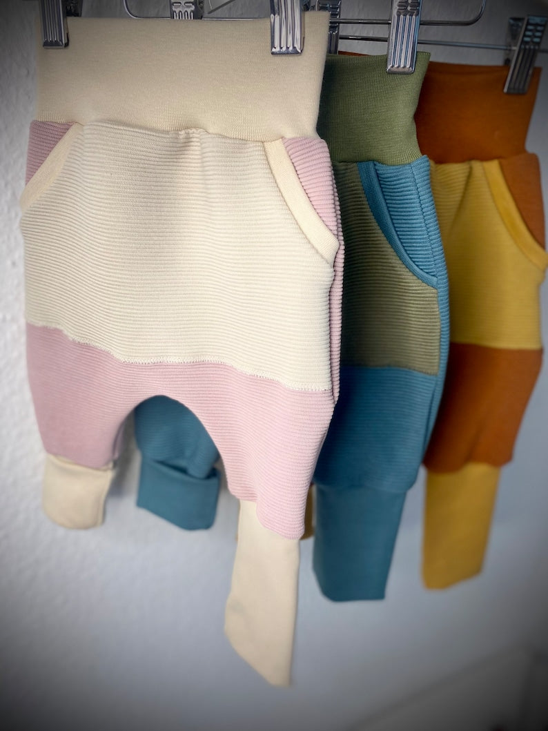 Drei Mix and Match Pumphosen für Kleinkinder in rosa, blau und rot.