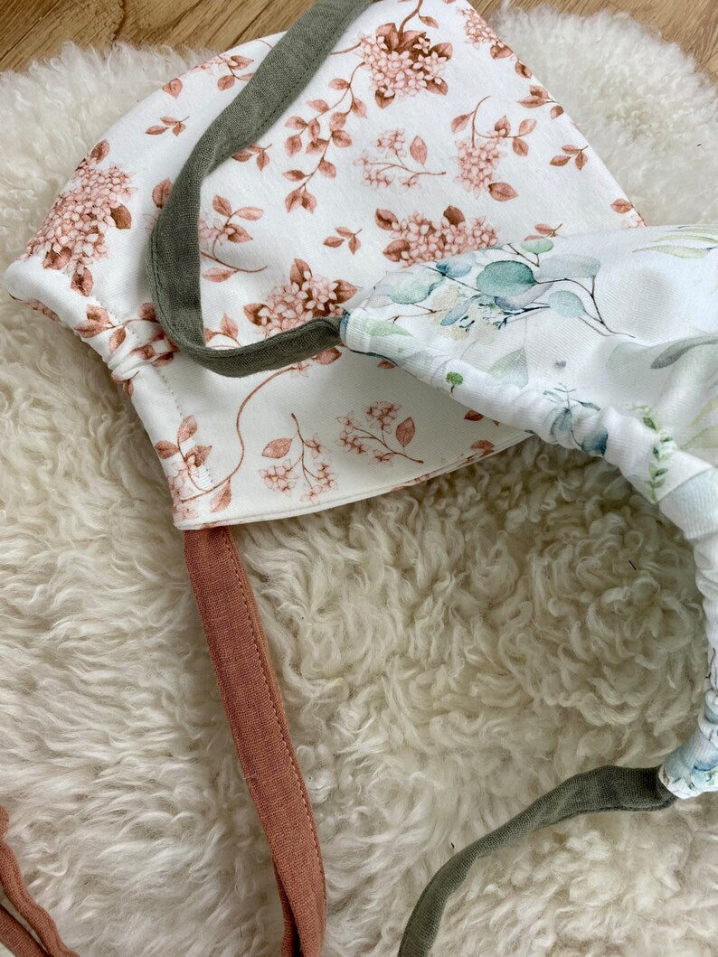 Zwergenmütze aus Jersey für Kleinkinder in weiß mit braunem Blumenmuster.