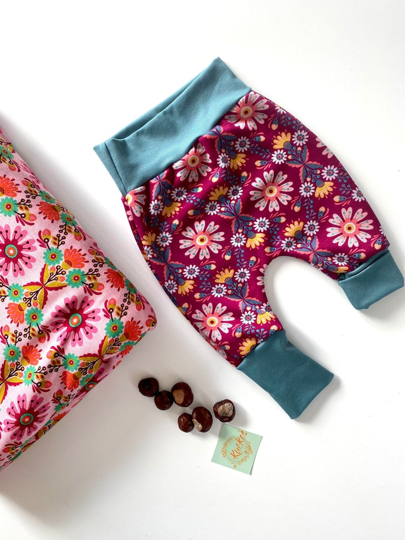 Pumphose für Kleinkinder aus Alpenfleece mit Blumenmuster in Weinrot und Rosa.