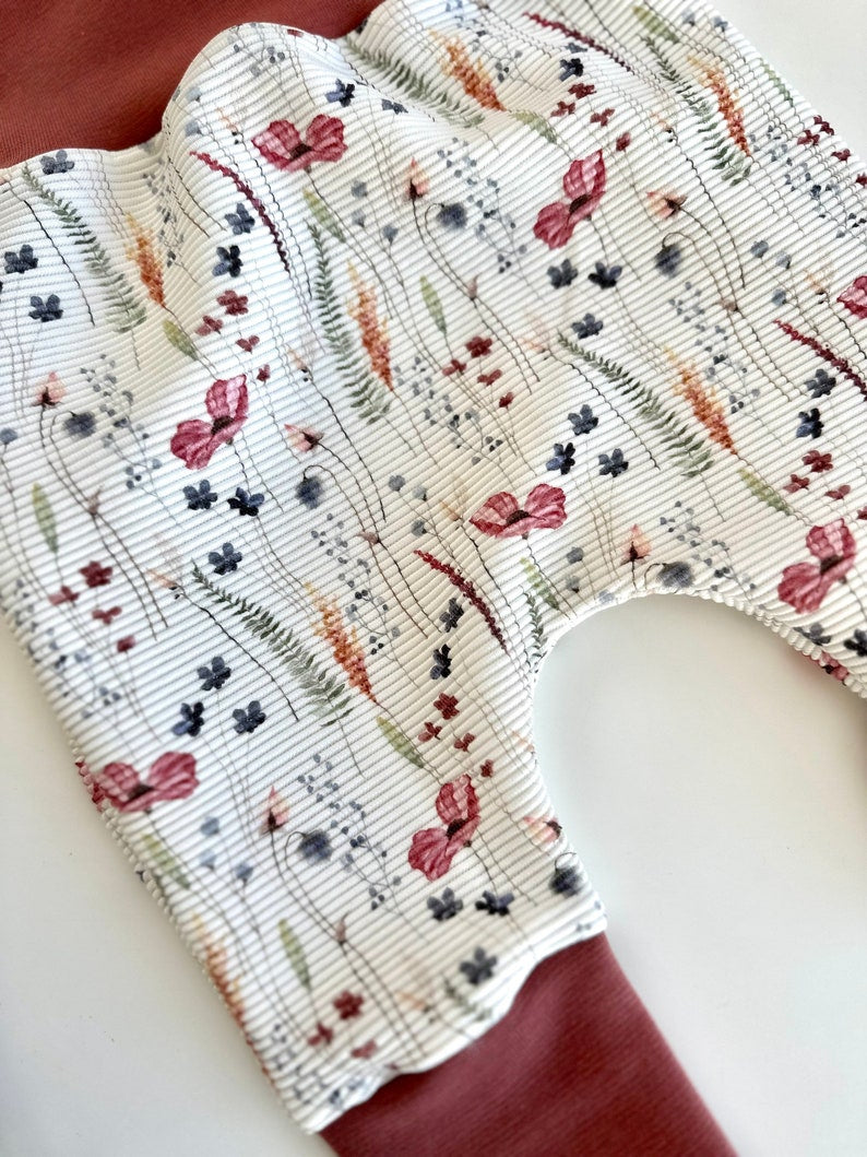 Pumphose für Kleinkinder mit Stoff aus Ribjersey mit Blumenmuster auf weißem Stoff.