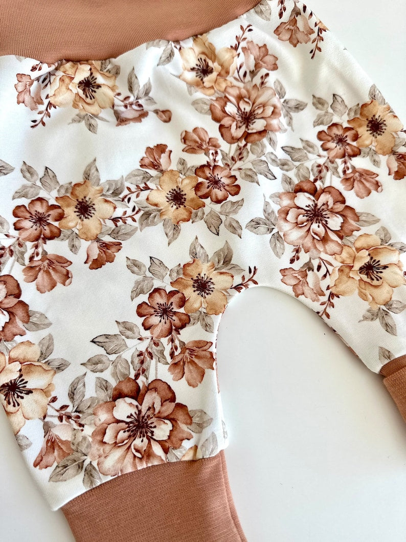 Pumphose für Kleinkinder mit französischem Blumenmuster in Braun auf weißem Stoff.