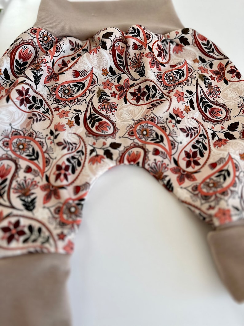 Pumphose für Kleinkinder mit Stoff aus Ribjersey mit Paisleyblumen und hellbraunen Bündchen.