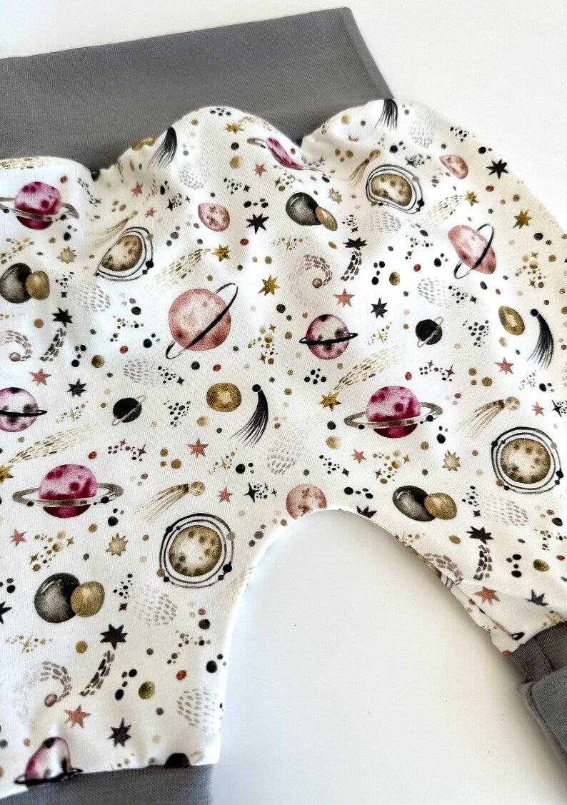 Pumphose für Kleinkinder mit Stoff aus Ribjersey mit Planetenmuster, weißem Grund und Bündchen in Grau.